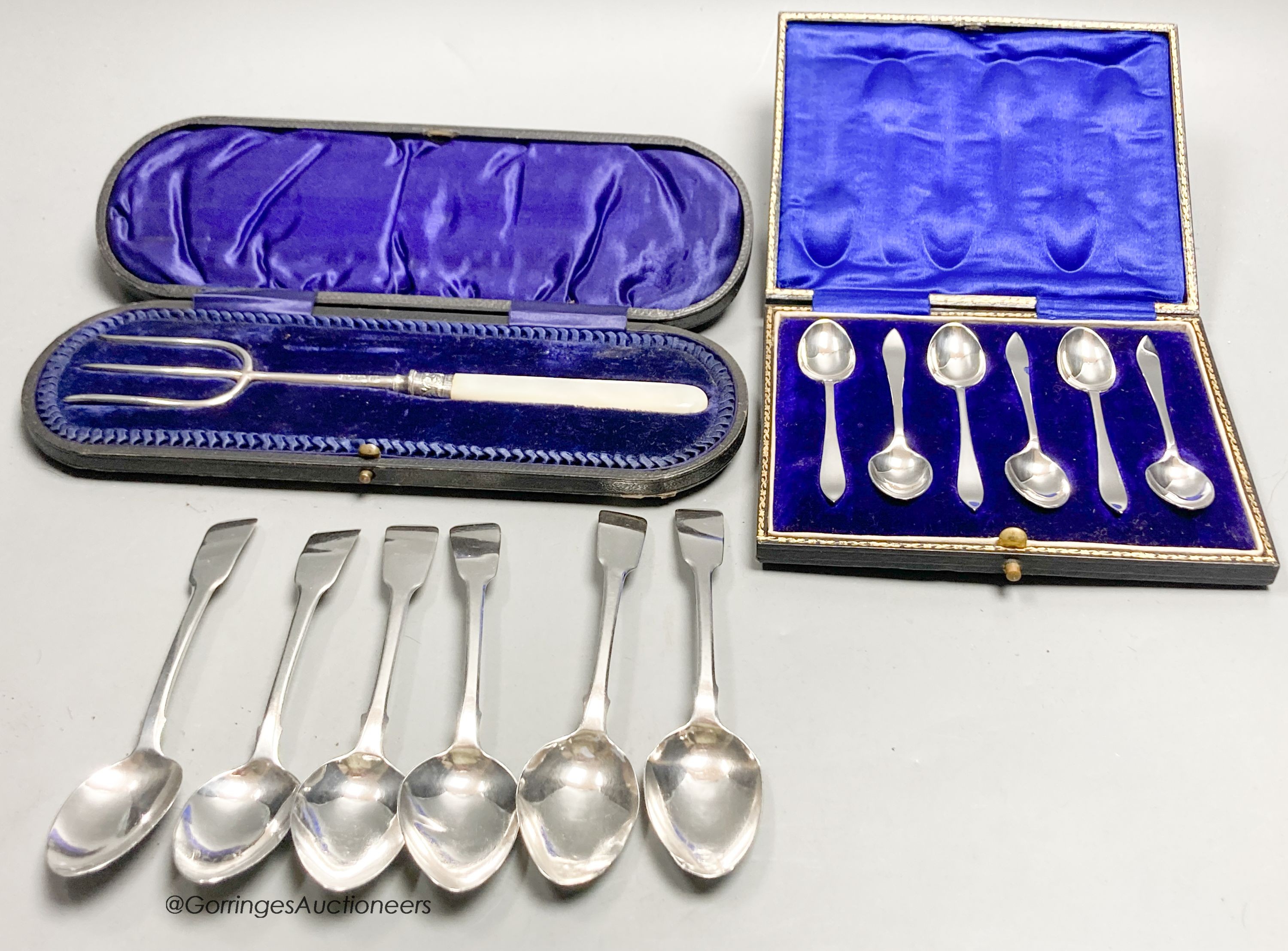 A set of six George IV silver fiddle pattern teaspoons, London, 1823, a later cased set of six silver coffee spoons and a cased mother of pearl handled silver toasting fork.
